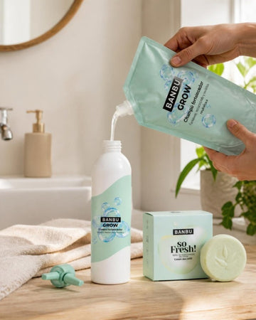 Manos rellenando el bote de champú GROW con su recarga, junto al refill de desodorante SO FRESH de BANBU