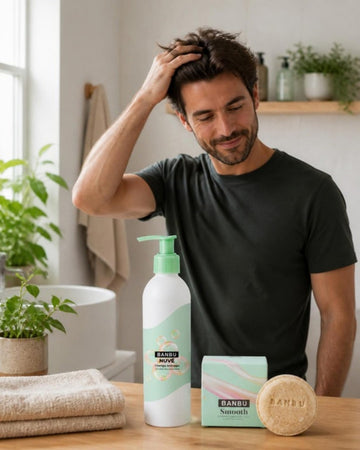 Hombre en un baño luminoso junto al champú anticaspa NUVÉ y el champú sólido SMOOTH de BANBU