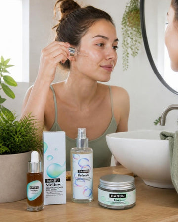 Mujer joven aplicándose sérum junto al sérum MELLOW, el tónico REFRESH y la mascarilla purificante de BANBU