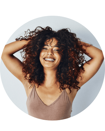 Mujer sonriendo con el pelo rizado definido y voluminoso