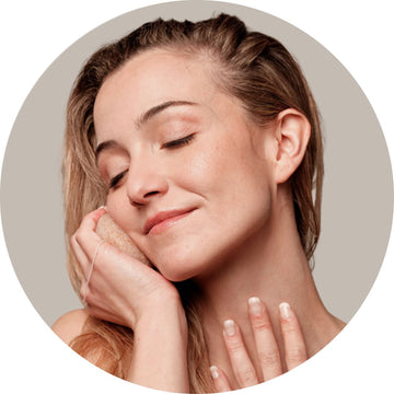 Chica limpiándose el rostro con una esponja konjac facial, eliminando impurezas de forma suave y natural para una piel fresca y equilibrada