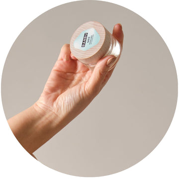Mujer sosteniendo un perfume sólido natural de Banbu, lista para aplicarlo. Un gesto sencillo para llevar su aroma favorito a todas partes