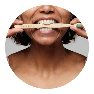 Chica presumiendo de sonrisa sujetando entre los dientes el cepillo de dientes