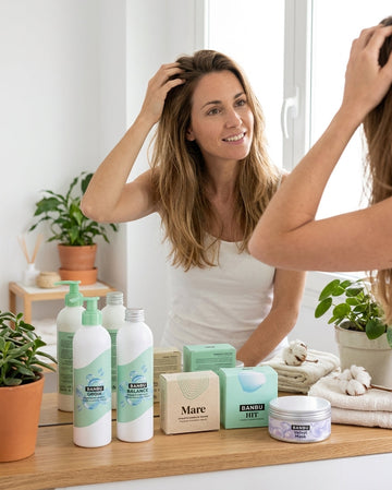 Chica tocándose el pelo en un baño junto a productos naturales para pelo graso de BANBU