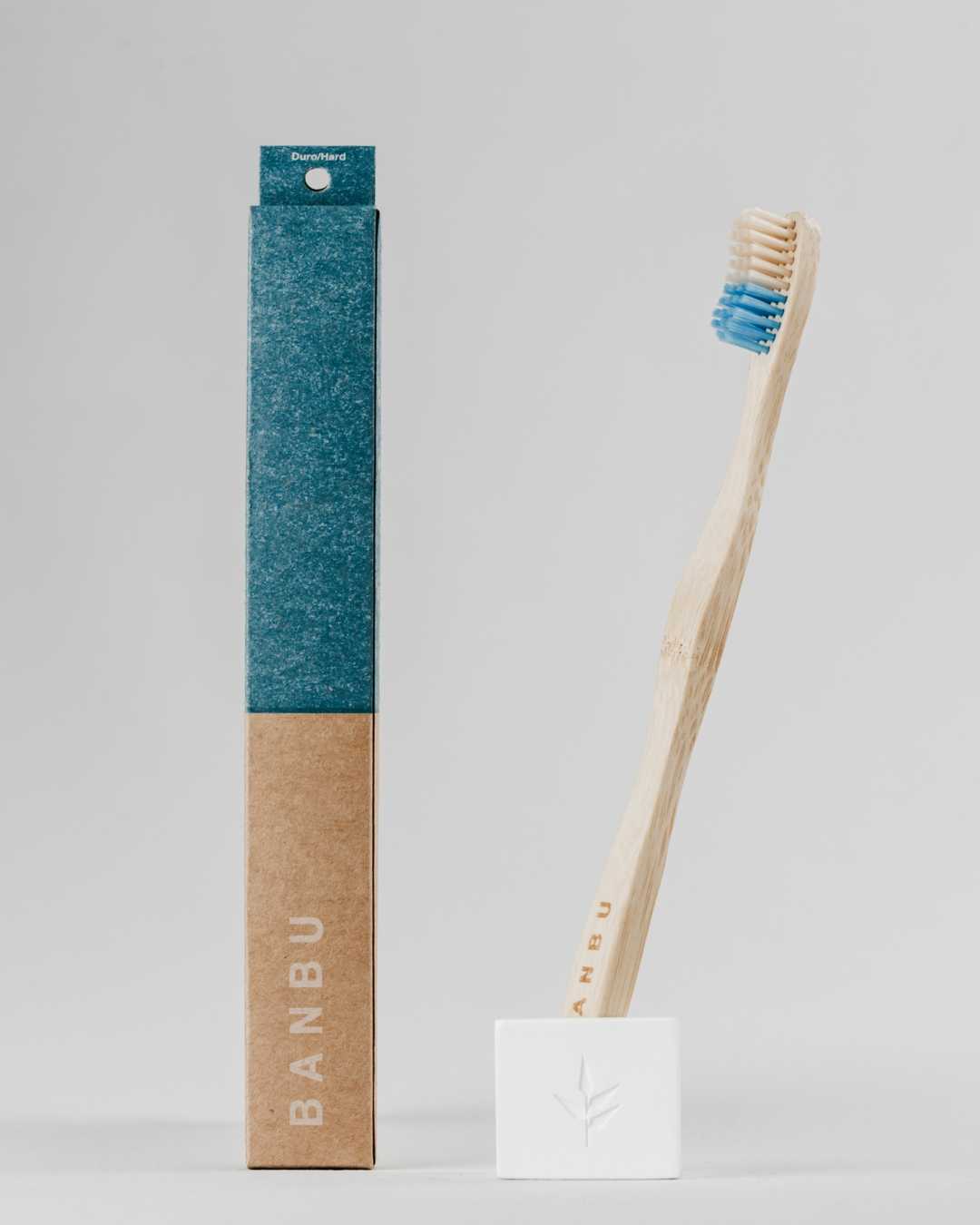 Cepillo de dientes duro de bambú azul con packaging biodegradable y sin plástico
