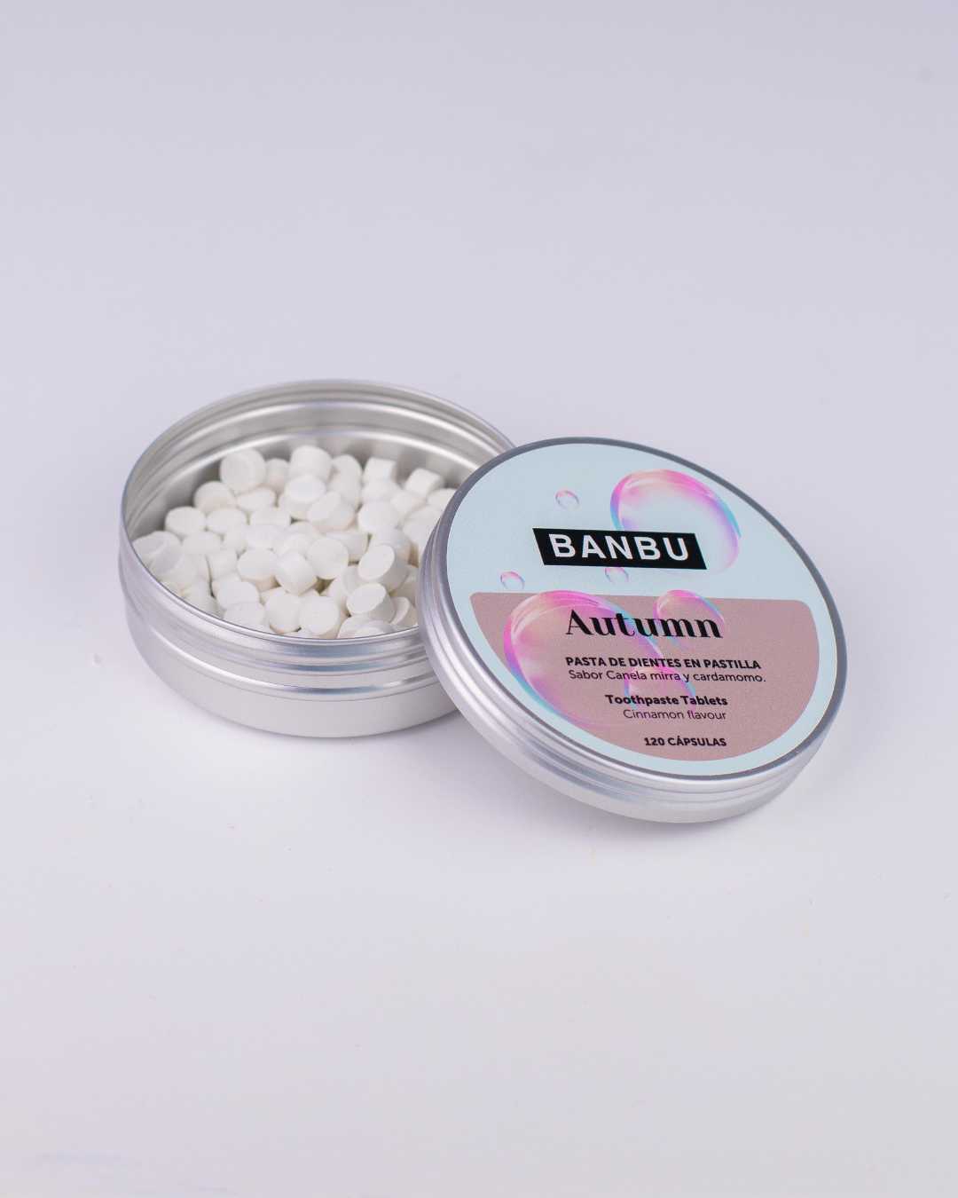 Envase reutilizable y abierto de Autumn de Banbu, mostrando las pastillas de dentífrico sin flúor, vegano y zero waste con un refrescante sabor canela para combatir la placa dental.