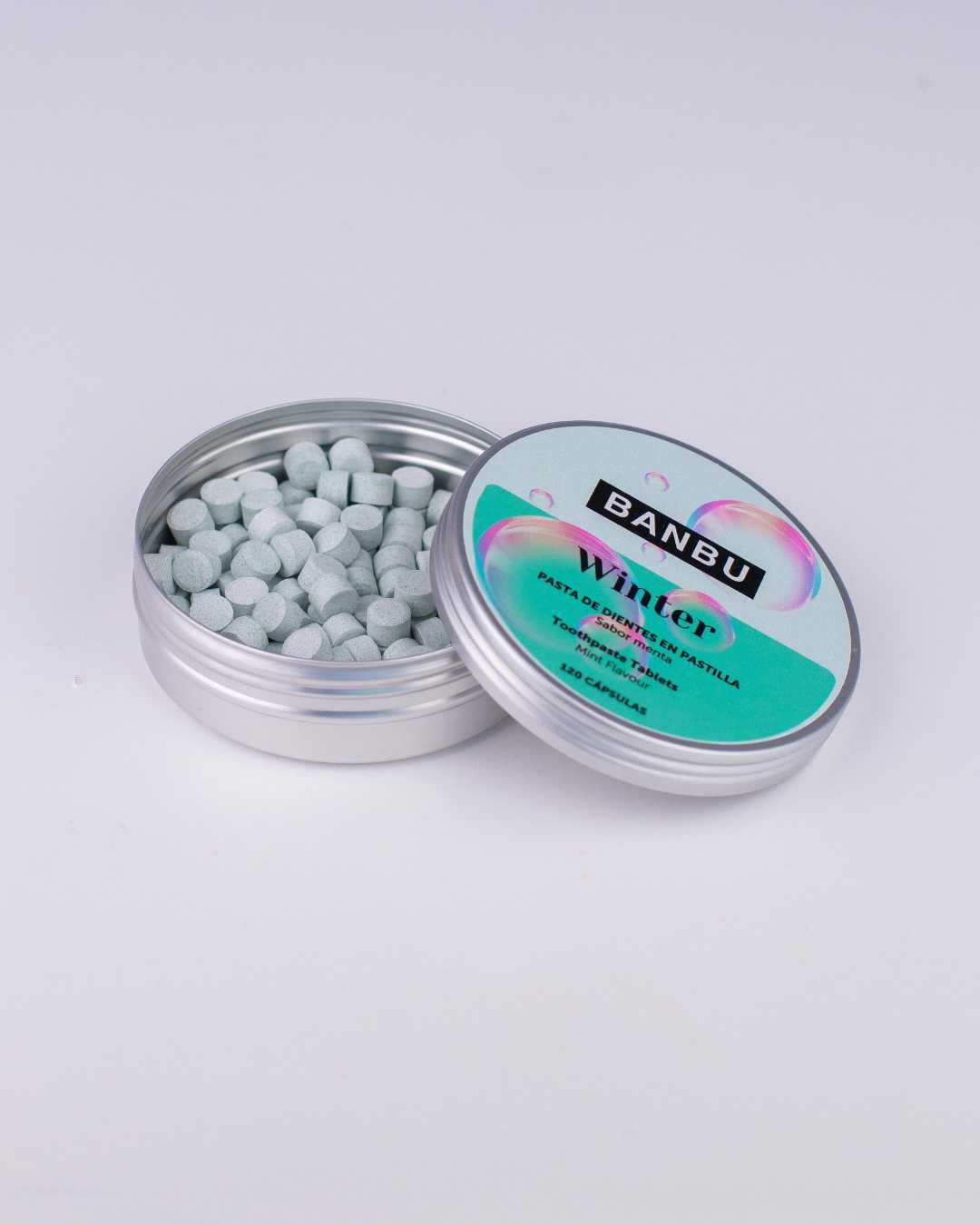 Envase sostenible abierto mostrando las pastillas de la pasta de dientes sin flúor y vegana Winter de Banbu, diseñada para un aliento fresco y cuidado antiinflamatorio.